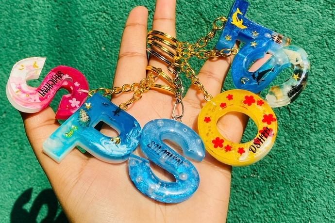 Colourful personalized resin name letters in different colours, held in hand