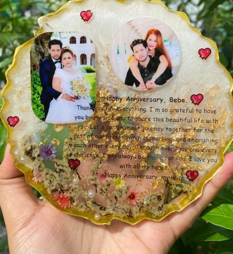 The same anniversary resin frame held against greenery