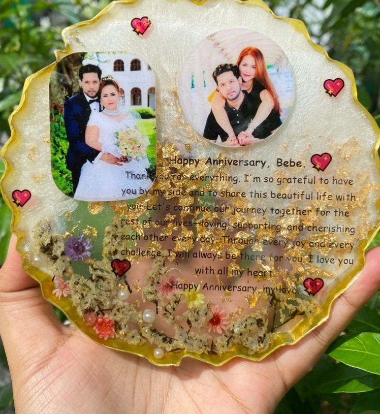 The same anniversary resin frame held against greenery